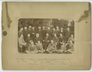 photographie de classe de l'école Alsacienne, année 1887-1888, légendée, avec André Gide, premier à gauche des élèves debout, la main sur l'épaule de Pierre Louÿs