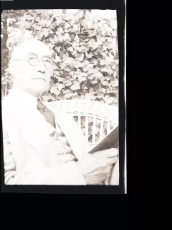 portrait photographique d'André Gide, de ¾ face, la tête légèrement renversée, la main droite tenant un livre, mai 1930