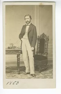 portrait photographique en pied de Paul Gide, devant un bureau