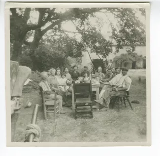 photographie montrant Élisabeth Van Rysselberghe, au centre, et la famille Caramello, fermiers à la Bastide Franco, attablés sous un arbre, à la Bastide Franco