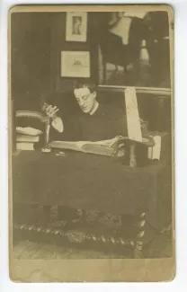 portrait photographique de Jules Laforgue [?], assis à un bureau lisant