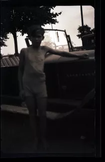 photographie d’un adolescent, près d’une voiture