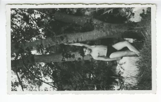 photographie d’un adolescent en maillot de bain, près d’un arbre
