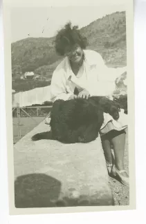 photographie de Miss Todd, la nurse de Catherine Gide, avec le chien Niska et un chiot, dans le jardin de la villa Le Pin, à Saint-Clair