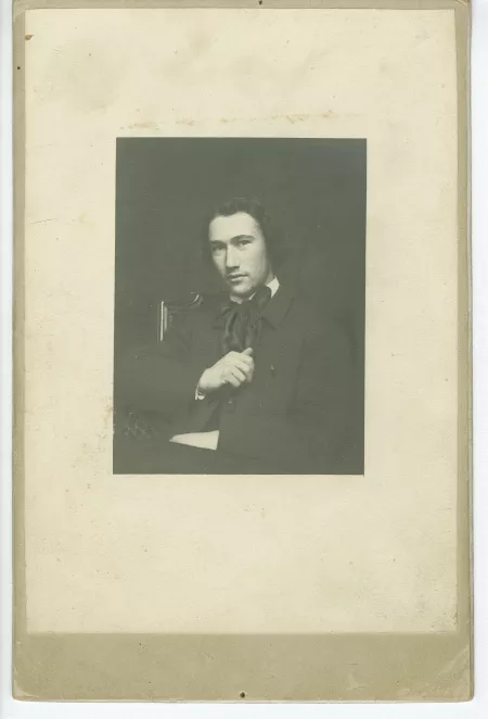 portrait photographique d’André Gide, assis, de face, la main droite sur la poitrine