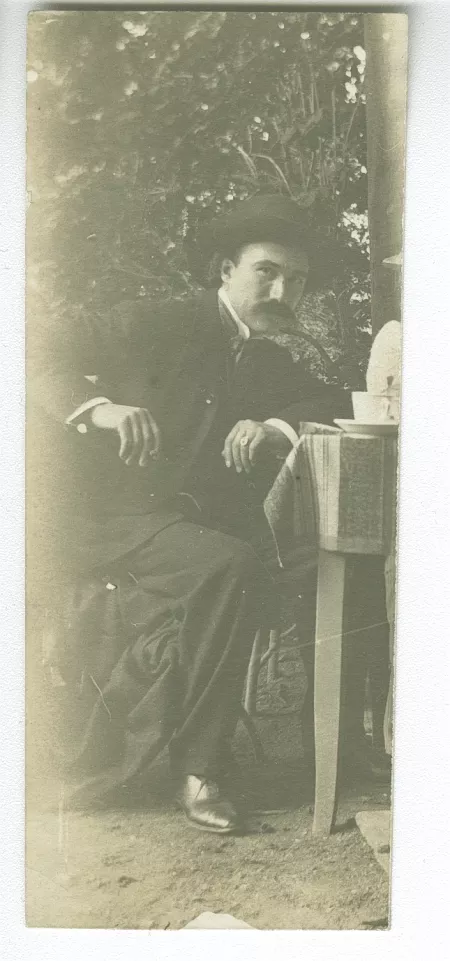 photographie d’André Gide, avec moustache et chapeau, assis à table, en visite à Tiefurt, août 1903
