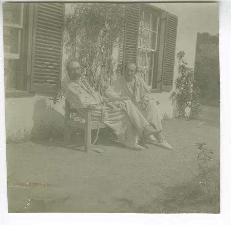 photographie d’André Gide, avec moustache, et Jacques Copeau, tous deux en peignoir, assis sur un banc devant la maison louée par les Copeau à St. Brelade, août-septembre 1907