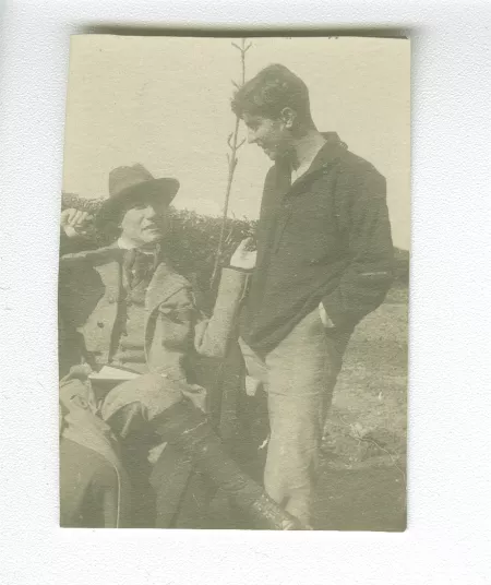 photographie d’André Gide, avec chapeau, assis, et Marc Allégret, à Garsington Manor, Oxfordshire, chez Lady Ottoline Morrell, lors de leur séjour en Angleterre, août 1920