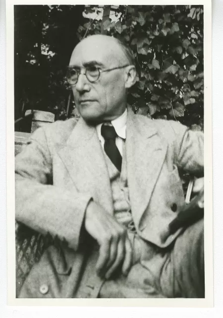 portrait photographique d'André Gide, de 3/4 gauche, un livre en main, mai 1930