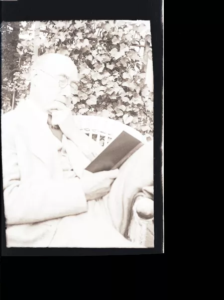 portrait photographique d'André Gide, de ¾ droit, lisant, la main gauche sur le menton, mai 1930