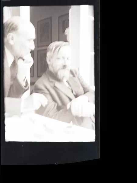 photographie d'André Gide, de profil, fumant, main gauche sur la joue, et Bernard Groethuysen, cigarette en bouche, tous deux souriant, juillet 1931