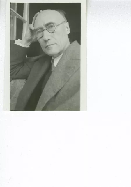 portrait photographique en buste d'André Gide, avec lunettes, la main droite sur le crâne, regardant l'objectif, juillet 1931