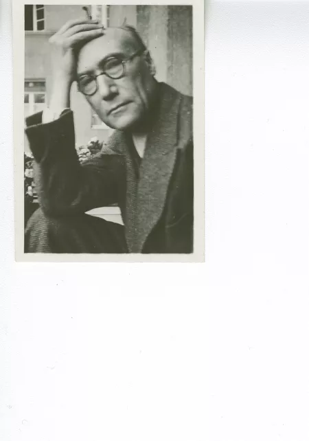 portrait photographique en buste d'André Gide, avec lunettes, regardant l'objectif, la main droite avec cigarette sur le front, juillet 1931