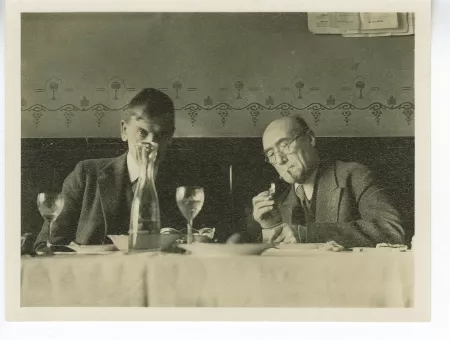 photographie d’André Gide, allumant une cigarette, et Charles-Ferdinand Ramuz, lors d’un déjeuner à La Crochette, 9 décembre 1933