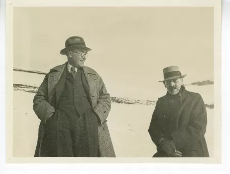 photographie d’André Gide, avec lunettes et chapeau, riant, et Charles-Ferdinand Ramuz, dans un paysage enneigé, au lac de Genève, décembre 1933