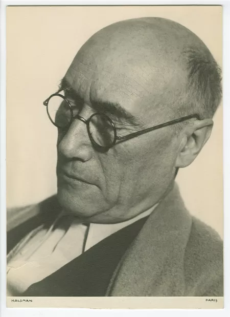 portrait photographique en gros plan d’André Gide, avec lunettes, de ¾ à gauche, regardant vers le bas