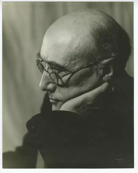 portrait photographique en gros plan d’André Gide, avec lunettes, de profil à gauche, regardant vers le bas, la main gauche sur la joue