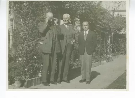 photographie montrant, de gauche à droite, André Gide, chaussant ses lunettes, Jean Pasquier [?], directeur de l'Institut français de Naples, et Robert Levesque, décembre 1945