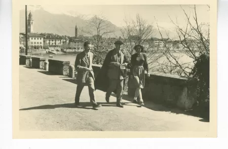 photographie d’André Gide, avec lunettes et béret, Jean Lambert et Catherine Gide, marchant sur la promenade du bord du lac, avril 1947