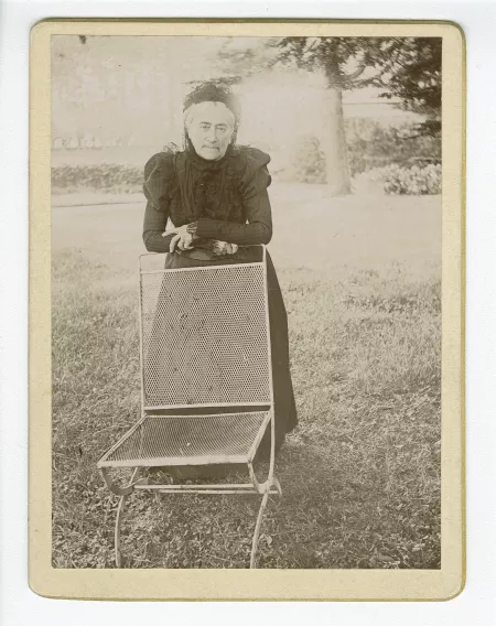 photographie de Claire Démarest, tante maternelle d'André Gide, accoudée à une chaise, dans le jardin du château de Cuverville