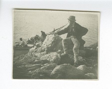 photographie de Théo Van Rysselberghe, debout sur des rochers, face à la mer, à Saint-Clair