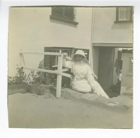 photographie de Maria Van Rysselberghe, assise sur un escalier, portant une coiffe blanche, juillet-août 1907