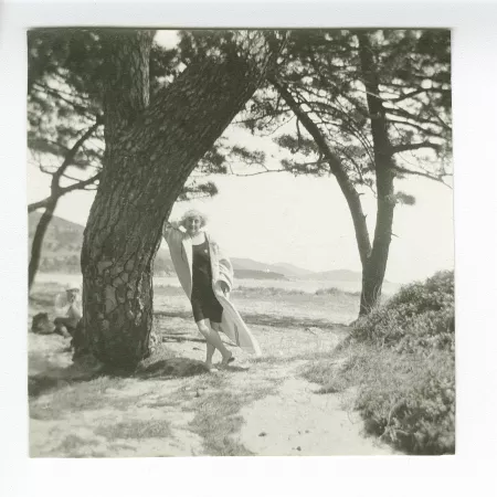 photographie de Maria Van Rysselberghe, debout accoudée à un arbre, sur une plage, à Saint-Clair
