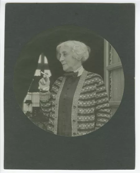 portrait photographique en buste de Maria Van Rysselberghe, fumant devant une porte-fenêtre, au château du Tertre, chez Roger Martin du Gard, mai 1927