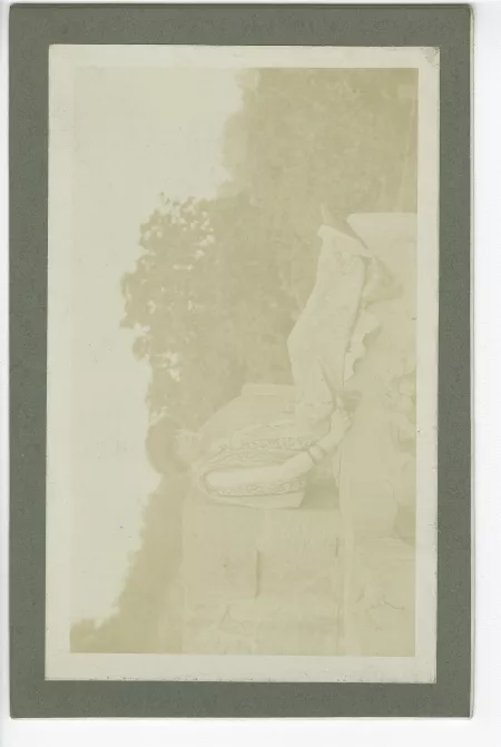 portrait photographique de Lucie Delarue-Mardrus, assise sur des pierres