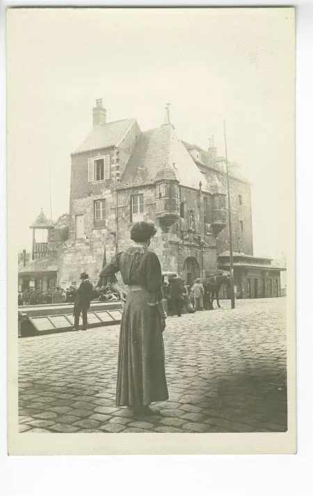 photographie de Lucie Delarue-Mardrus, de dos, devant un attroupement