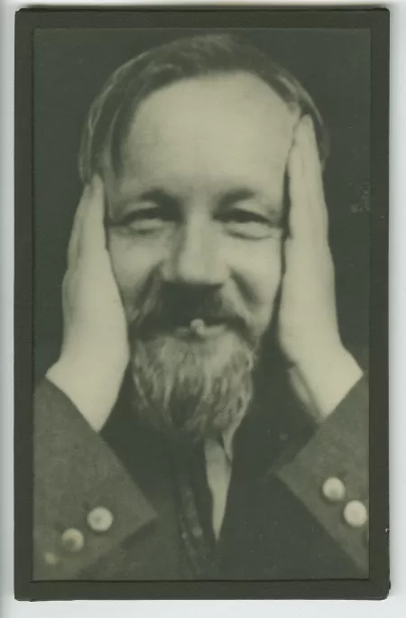 portrait photographique en gros plan de Bernard Groethuysen, de face, fumant, les mains sur les tempes, juillet 1931