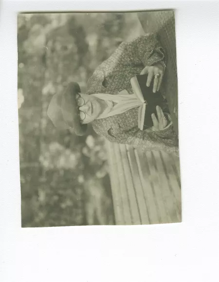photographie d'Aline Mayrisch, lisant, assise sur un banc, avril 1927