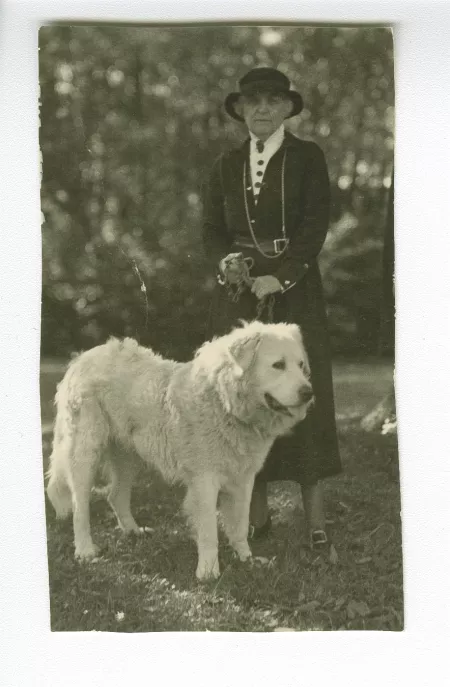 portrait photographique en pied d'Aline Mayrisch, tenant en laisse le chien Hund, en extérieur