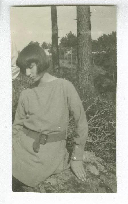 photographie d'Andrée Mayrisch enfant, aux cheveux longs, assise, dans la campagne