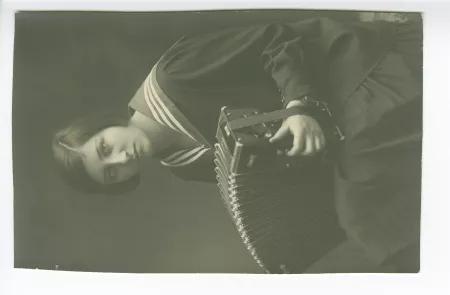 portrait photographique-carte postale d'Andrée Mayrisch adolescente, avec un accordéon
