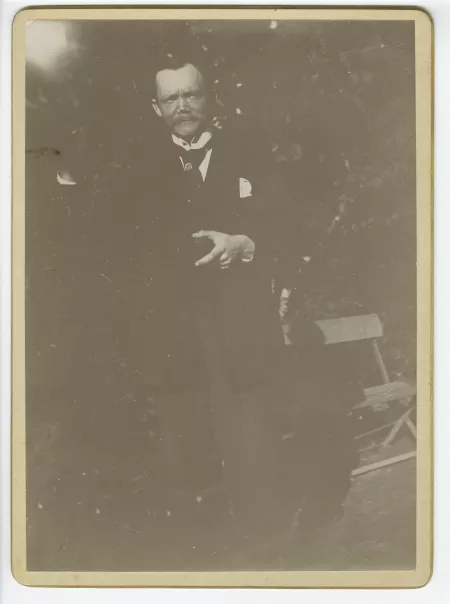 portrait photographique de Fédor Rosenberg, près d’un banc, dans le jardin de la propriété de Cuverville