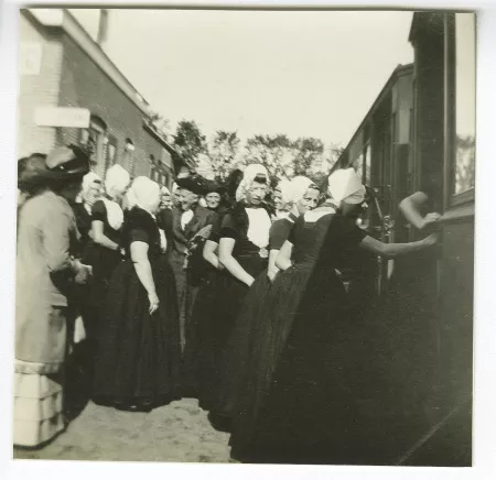 photographie d'un groupe de femmes devant un train, à la gare ferroviaire
