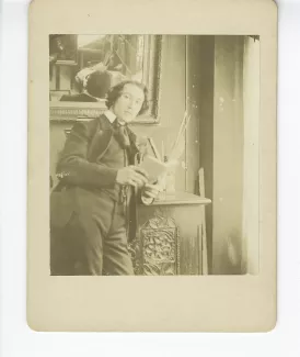 portrait photographique d’André Gide, accoudé à un buffet, tenant un livre