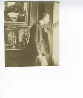 portrait photographique d’André Gide, de profil, tenant un livre et regardant par la fenêtre