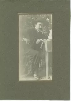 photographie d’André Gide, avec moustache et chapeau, assis à table, en visite à Tiefurt, août 1903