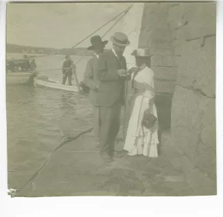 photographie montrant André Gide, avec moustache et chapeau, Henri Ghéon et Maria Van Rysselberghe, sur un débarcadère, août-septembre 1907