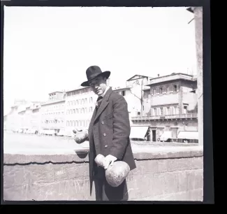 photographie d'André Gide, avec chapeau, sur le Ponte Vecchio, deux calebasses à la main, lors du voyage des Van Rysselberghe en Italie, avril 1909