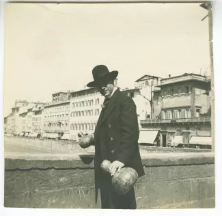 photographie d'André Gide, avec chapeau, sur le Ponte Vecchio, deux calebasses à la main, lors du voyage des Van Rysselberghe en Italie, avril 1909
