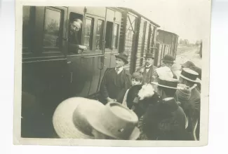 photographie de groupe avec, de gauche à droite, Edmund Gosse accoudé à la fenêtre du wagon, André Gide, derrière lui Francis Vielé-Griffin (chapeau melon, pipe) et Paul Desjardins (chapeau melon, de profil, un peu caché), à la gare de Pontigny, août 1912