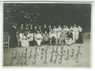 photographie-souvenir de groupe avec, de gauche à droite, debout : Pierre de Lanux, Jacques Raverat, André Gide, Henri Ghéon, Jean Schlumberger, Jacques Copeau, Maurice Emmanuel, Robert de Billy, Louis Canet, Blaise Desjardins, Marguerite Dinvault, Marie-