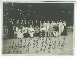 photographie-souvenir de groupe avec, de gauche à droite, debout : Pierre de Lanux, Jacques Raverat, André Gide, Henri Ghéon, Jean Schlumberger, Jacques Copeau, Maurice Emmanuel, Robert de Billy, Louis Canet, Blaise Desjardins, Marguerite Dinvault, Marie-