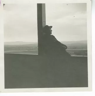 photographie d’André Gide, assis, le dos appuyé contre un pilier, sur le balcon d'une loggia à Brousse, en Anatolie, mai 1914