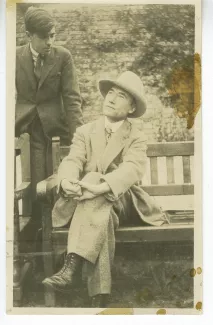 photographie d’André Gide, avec chapeau, assis sur un banc, et Marc Allégret, à Garsington Manor, Oxfordshire, chez Lady Ottoline Morrell, lors de leur séjour en Angleterre, août 1920