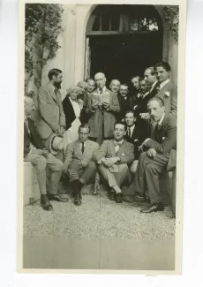 photographie de groupe avec, de gauche à droite, assis : Jean Schlumberger, Pierre Lansel, Jacques de Lacretelle, Marc Schlumberger et Pierre Viénot ; debout, de gauche à droite : Lytton Strachey, Maria Van Rysselberghe, Aline Mayrisch, Boris de Schloezer