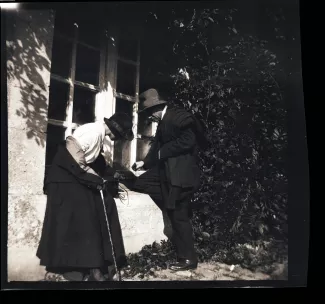photographie d'André Gide, avec chapeau, et Élisabeth Van Rysselberghe, enceinte de Catherine Gide, en extérieur près d’une grande fenêtre, janvier-février 1923